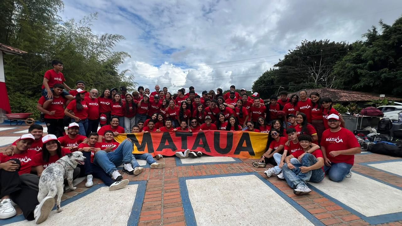 Grupo de jóvenes de MATAÜA con camisetas rojas y la pancarta del campo