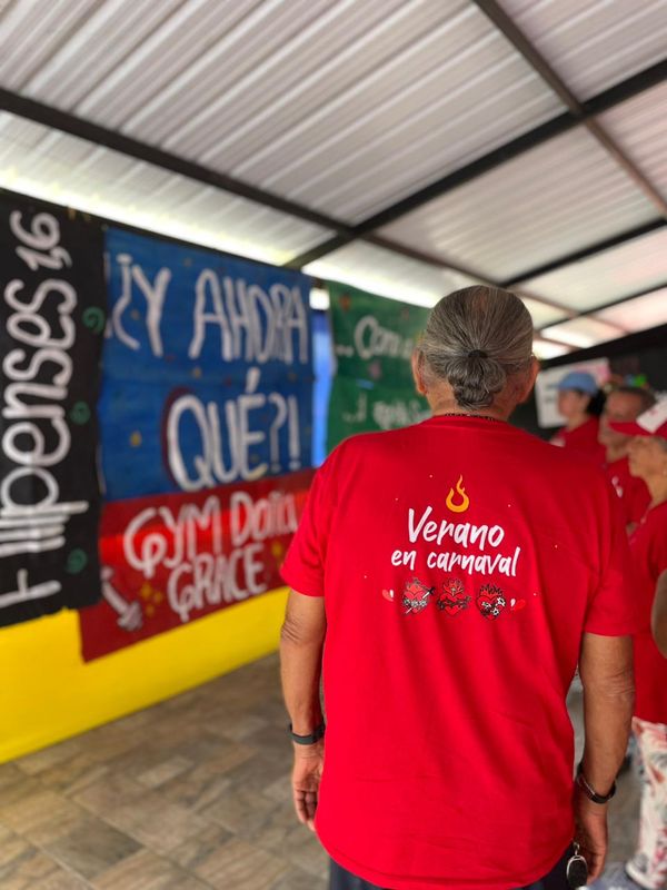Participante de MATAÜA SENIORS con la camiseta roja del campo frente a los murales del salón